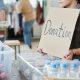 A nonprofit volunteer standing with a sign labeled “donation”