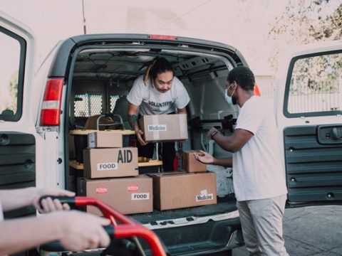 An NGO’s volunteers unloading boxes of food and medicine from a truck