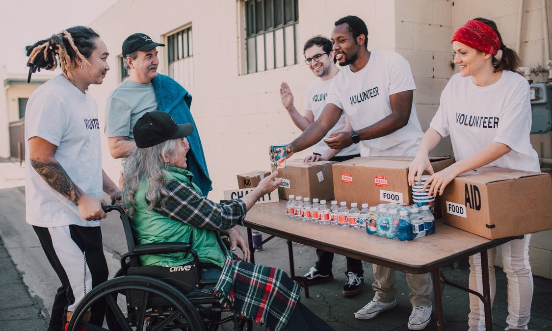 Fundraiser volunteers interacting with a disabled woman and her family