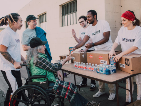 Fundraiser volunteers interacting with a disabled woman and her family