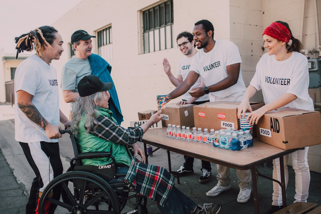 Fundraiser volunteers interacting with a disabled woman and her family