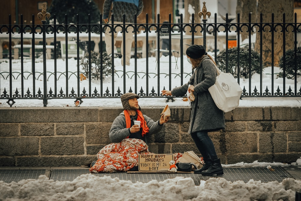 Woman giving food to a homeless man