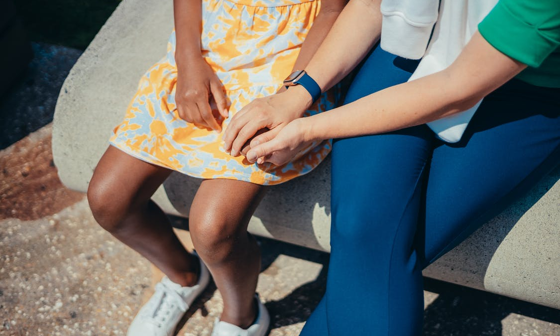 a woman holding a child's hand