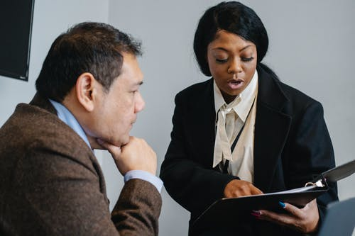  woman reading a contract to a man